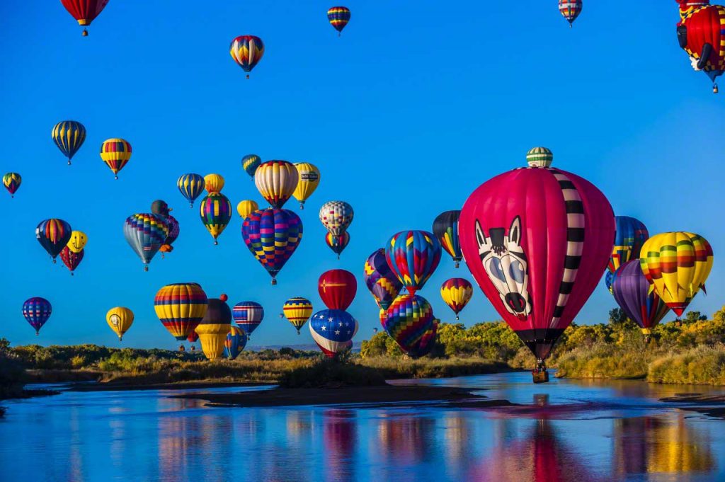 09 Oct 2012, Albuquerque, New Mexico, USA --- Hot air balloons flying low over the Rio Grande River just after sunrise, Albuquerque International Balloon Fiesta, Albuquerque, New Mexico USA. --- Image by © Blaine Harrington III/Corbis